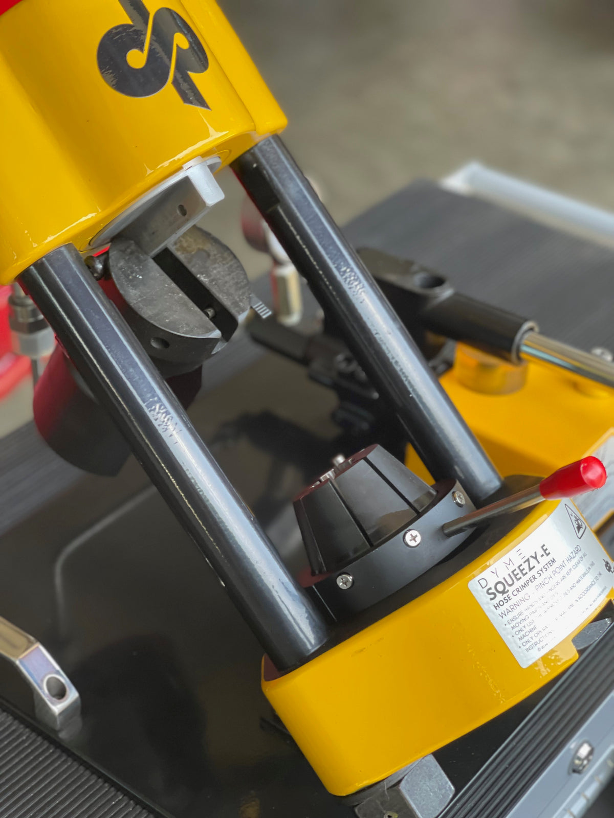 Close-up of a Squeezy-E hose crimping machine.