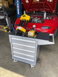 Dyme PRO hose crimper on a tool cart in front of a red car